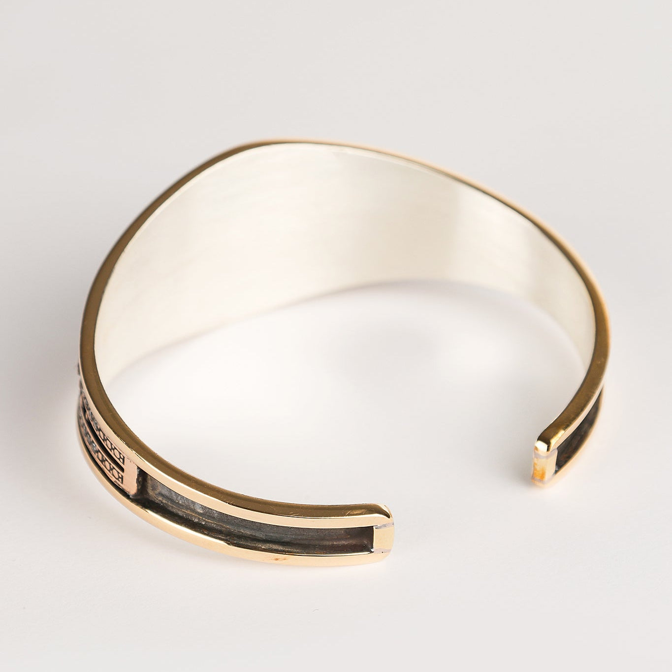 Gold bracelet on a light gray background