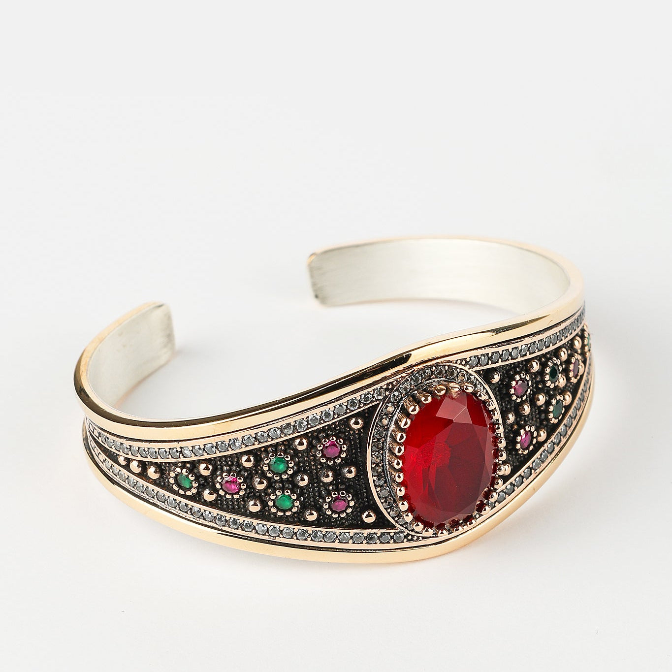 Decorative bracelet with a red gemstone on a white background
