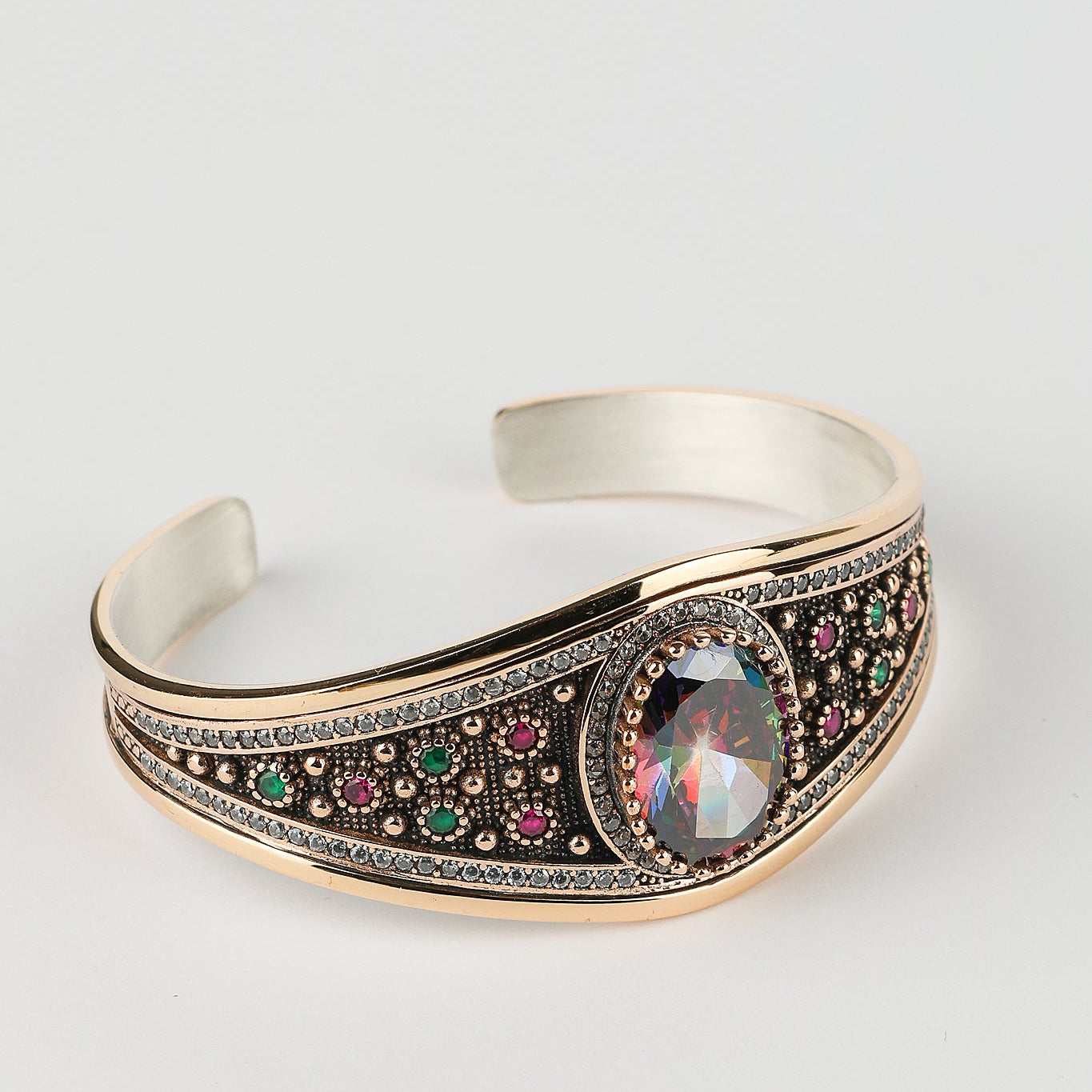 Silver bracelet with gemstone accents on a light gray background