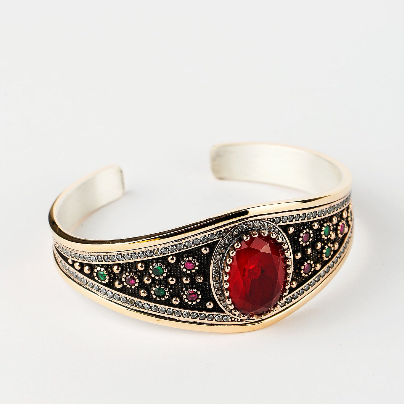 Decorative bracelet with a red gemstone on a white background