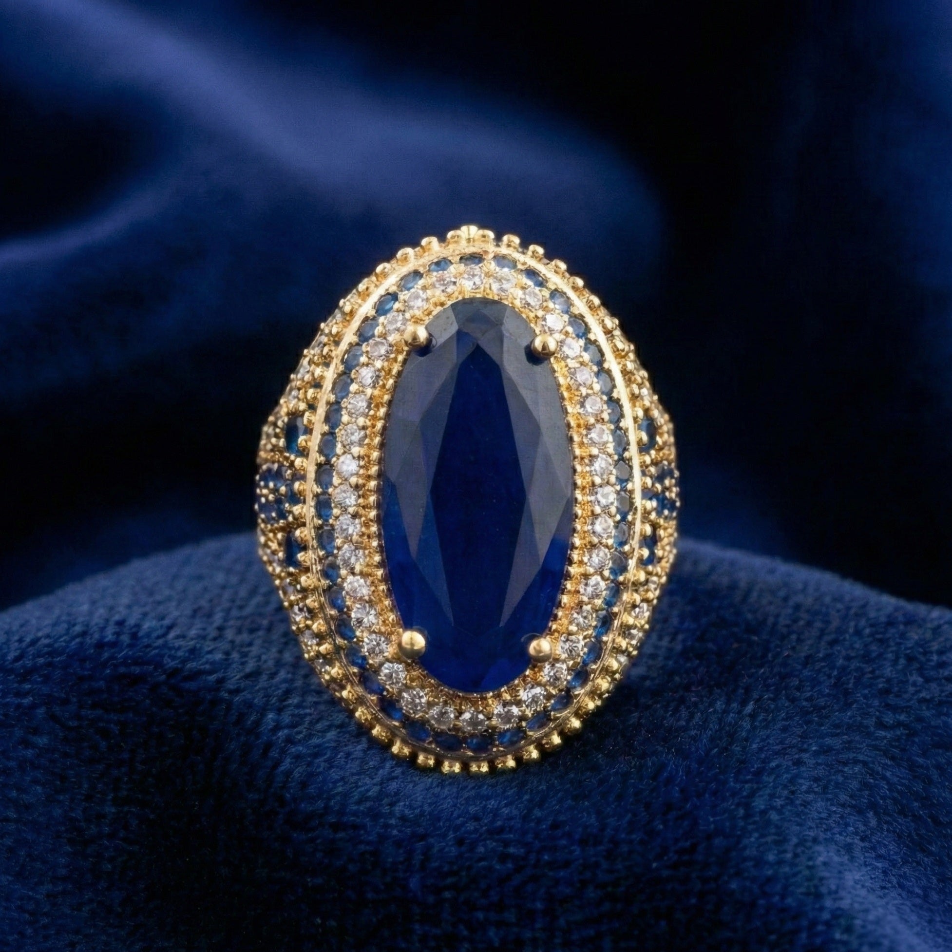 Gold and blue gemstone ring on a blue fabric background