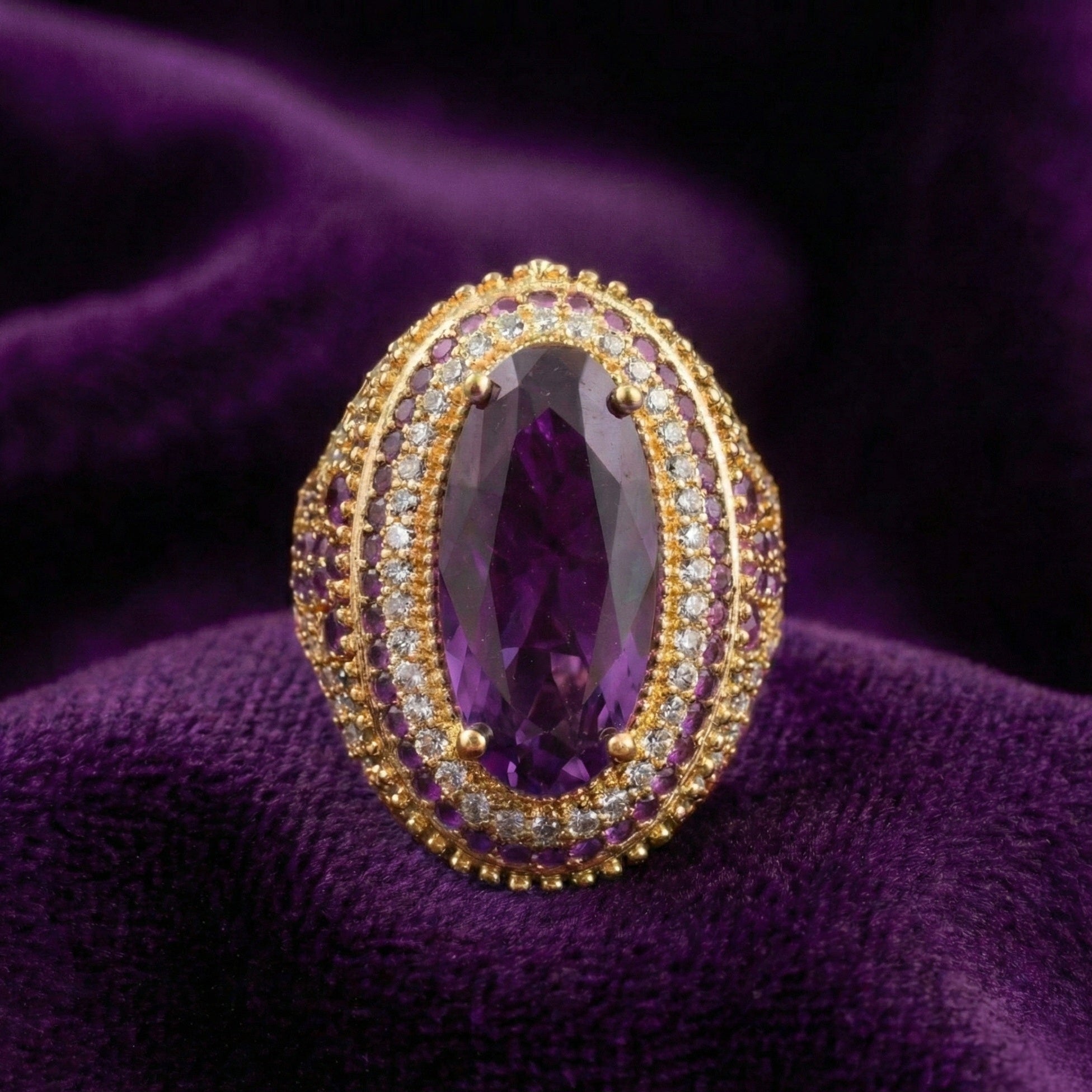 Gold ring with a purple gemstone on a purple fabric background