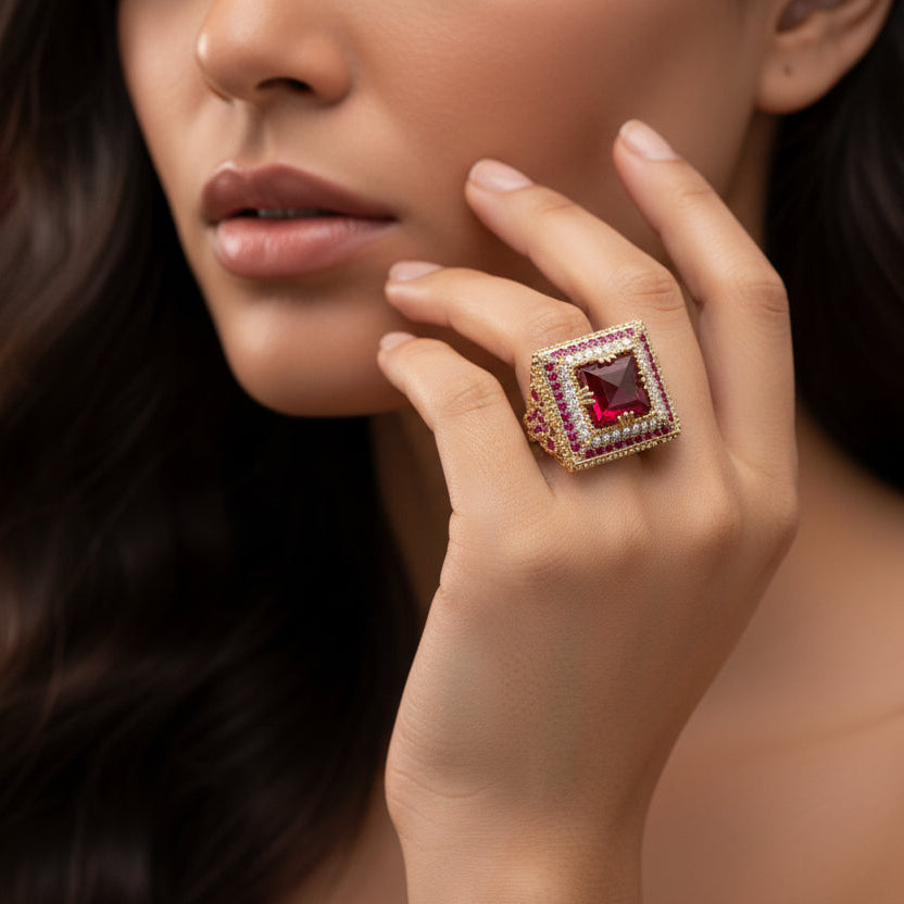 Luxury ring with a prominent red gemstone on a burgundy fabric background
