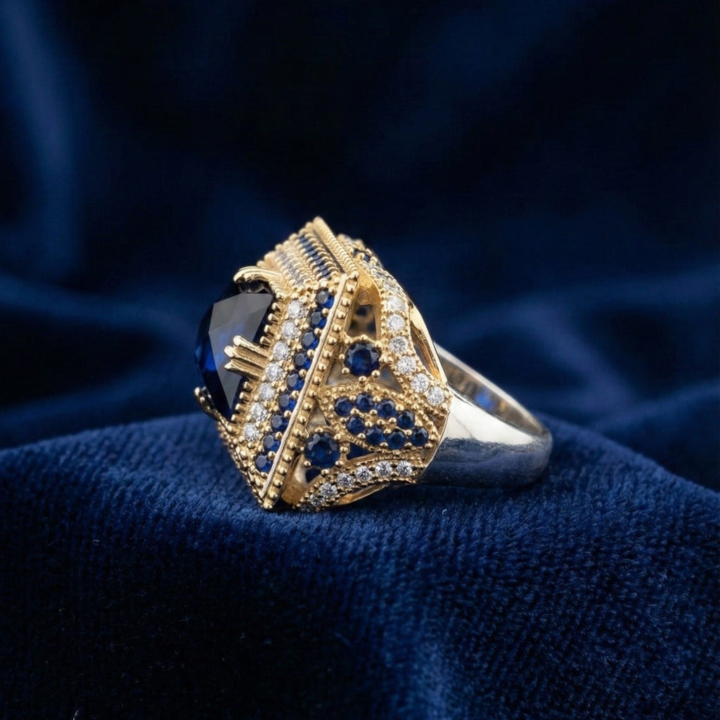Gold and silver ring with blue stones on a dark blue fabric background