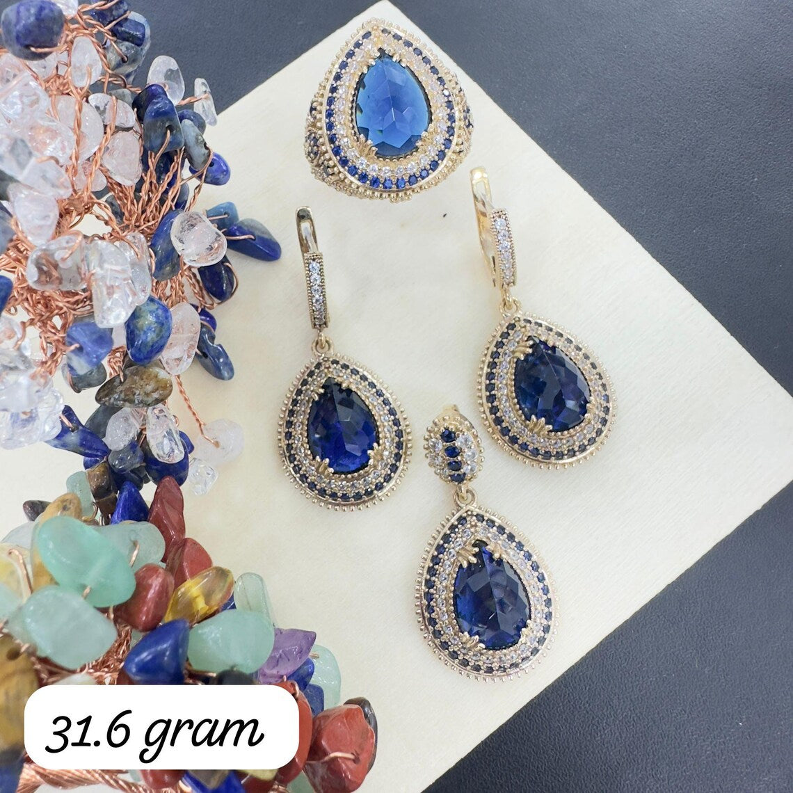 Jewelry set with blue teardrop earrings on a white surface