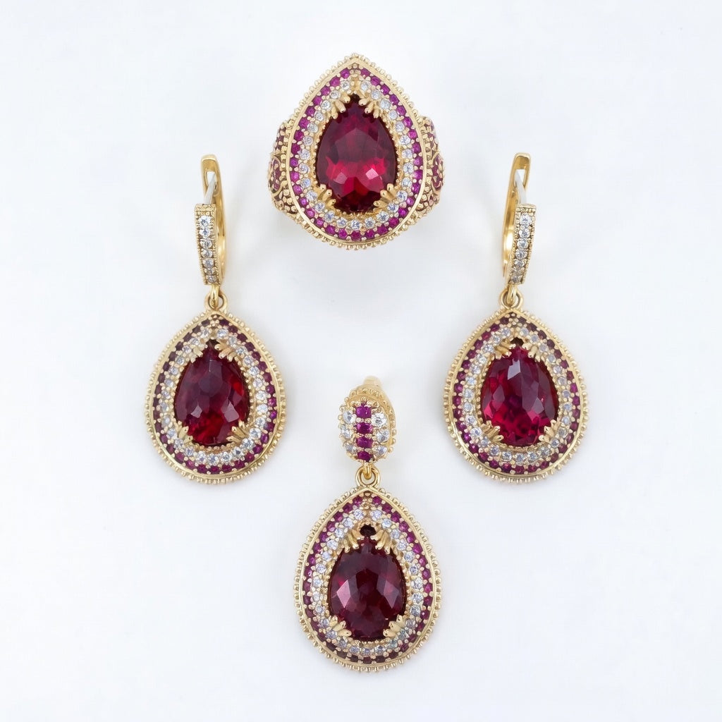 Gold earrings with red gemstones on a white background