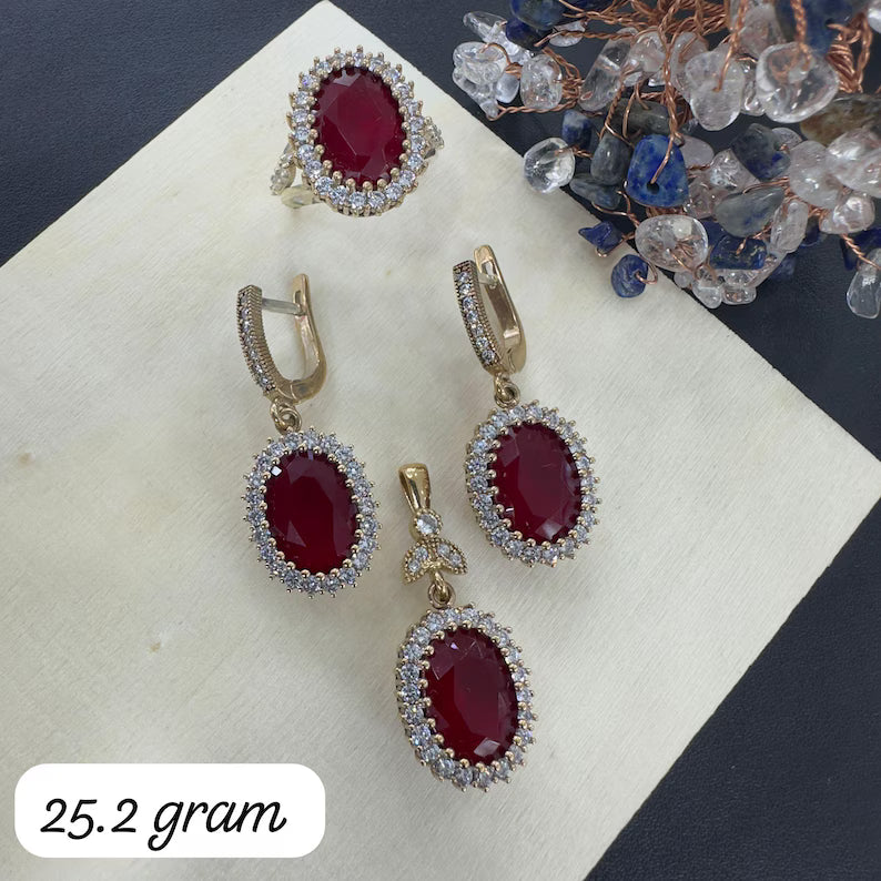 Jewelry set with red gemstones on a white surface