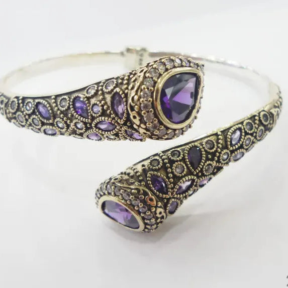 Silver bracelet with purple gemstones on a white background