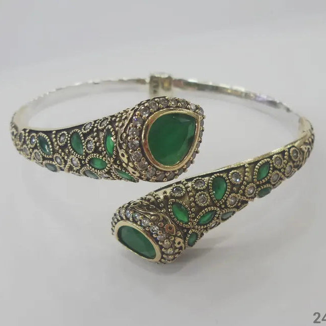 Jewelry set with green gemstones and silver accents on a white background