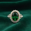 Elegant ring with a green gemstone on a green fabric background
