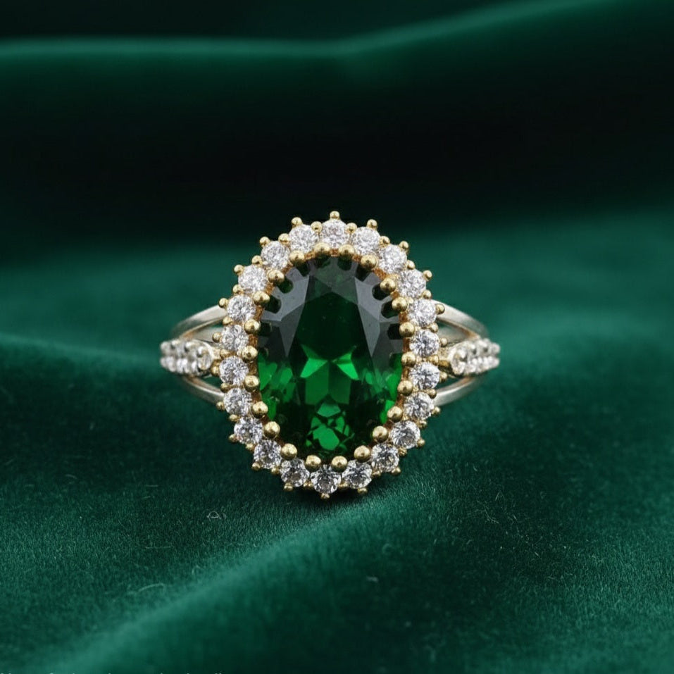 Elegant ring with a green gemstone on a green fabric background
